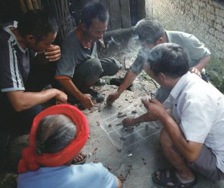 陰雨天,三五瑤民聚在一起玩瑤族傳統(tǒng)“趕豬棋”。